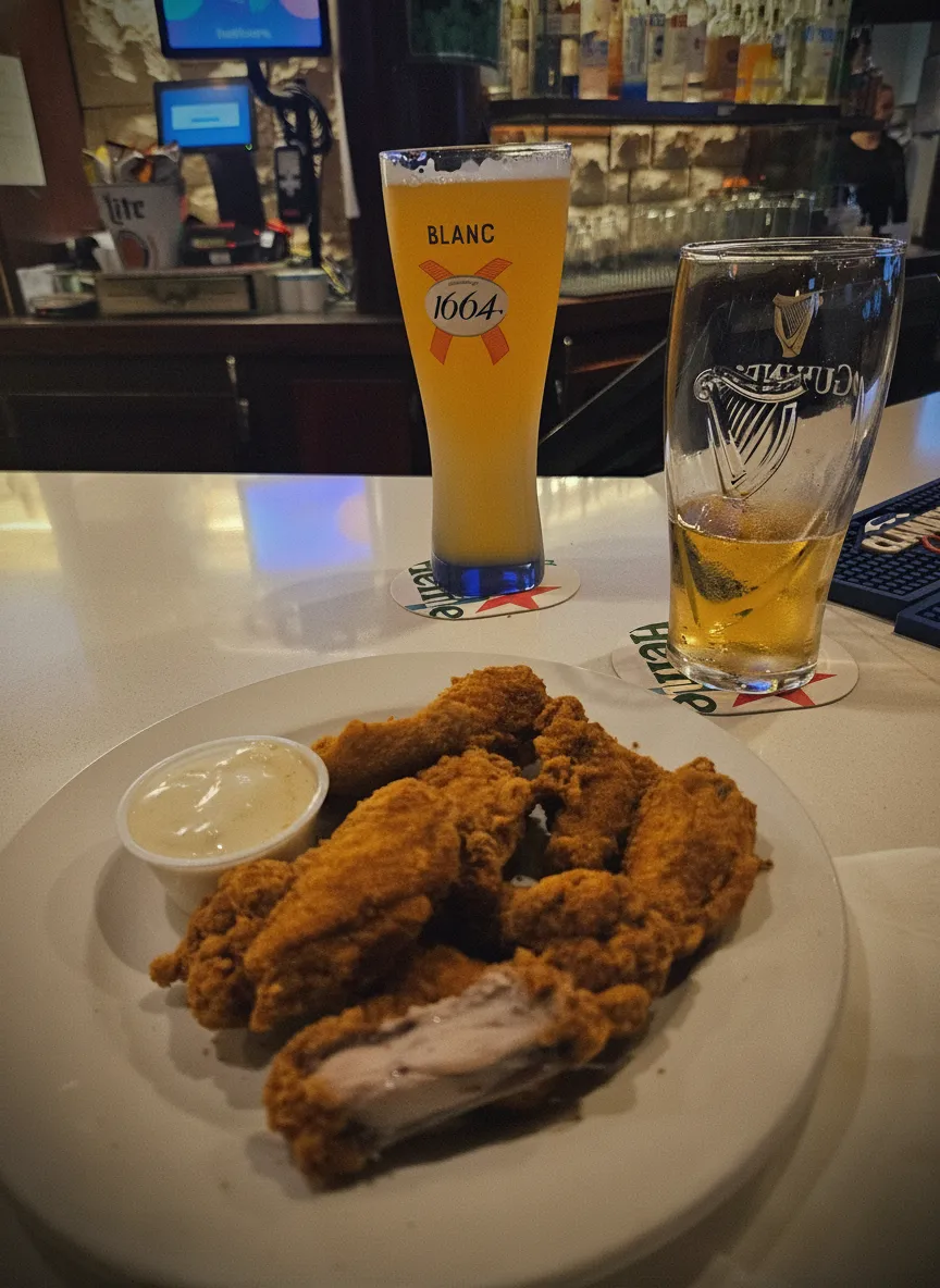 Plate of chicken tenders with dipping sauce and two beer glasses